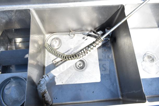 TSB-3-R2 Commercial 3 bay sink, stainless steel, no legs, right side drain boards, visible hand spray hose. Appears used.