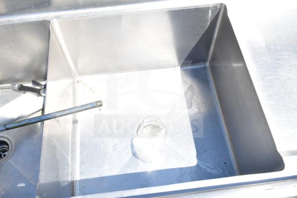 TSB-3-R2 commercial 3 bay sink with right side drain boards, no legs, visible faucet fittings, in used condition.