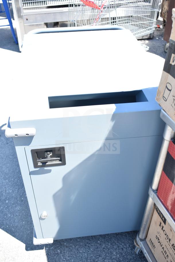 Gray metal unit with three compartments on commercial casters. Features a handle and visible screw on front.