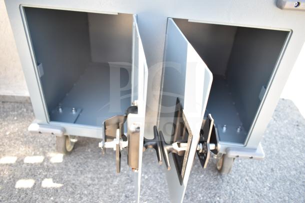 Gray metal unit with three open compartments on commercial casters, featuring sturdy hinges and secure latch mechanisms.
