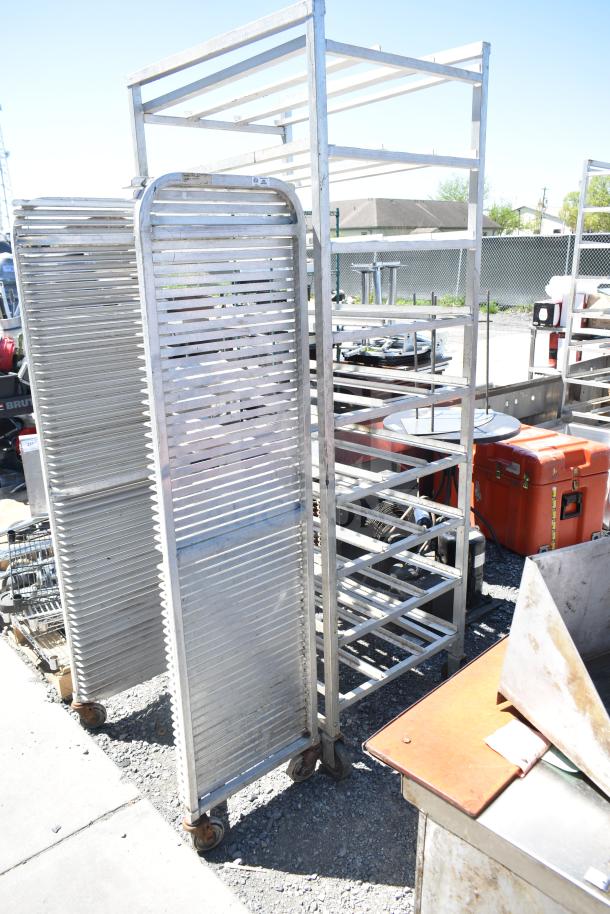 Two metal pans on commercial casters, durable structure, in used condition. Ideal for industrial or kitchen use.