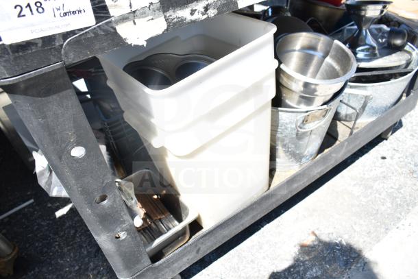 Black poly 2-tier cart holding skillets, white poly bins, and metal containers. Visible label reads "218 w/Contents."