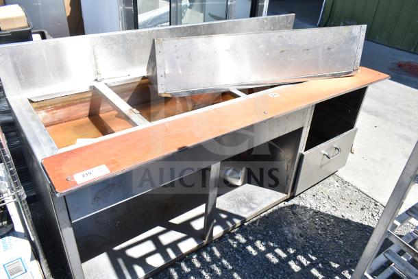Commercial steam table with under shelf, metal construction, visible wear and rust, includes a label marked "219 1/2".