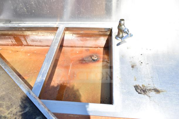 Commercial steam table with under shelf, featuring a visible water-filled compartment and spout, showing wear and rust.