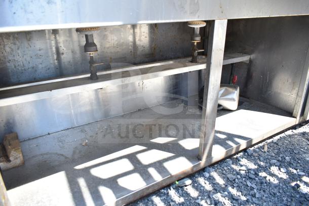 Commercial steam table with under shelf, stainless steel, visible gas fittings, and signs of wear. Ideal for caterers.