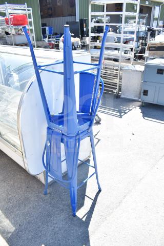 2 blue Tolix-style bar height chairs stacked, featuring a sleek finish. Ideal for modern settings. Like new condition.
