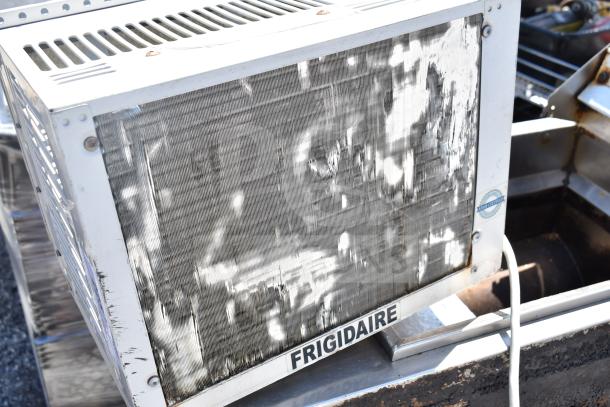 Frigidaire FAX052P7A window air conditioner, 115V, 1 phase. Metal casing shows wear; brand logo visible; suitable for auction.