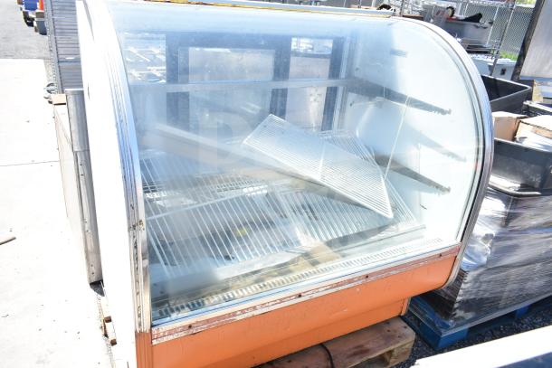 Leader CVK48 S/C deli display case, curved glass, worn exterior, interior racks, 115 volts, 1 phase, commercial use.