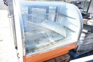 Leader CVK48 S/C deli display case, curved glass, worn exterior, interior racks, 115 volts, 1 phase, commercial use.