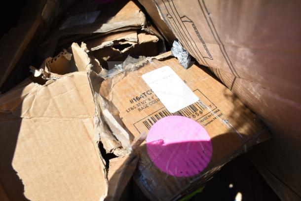 Damaged cardboard boxes containing 16 new scratch and dent items, including trash cans and ingredient bins. Tags and labels visible.