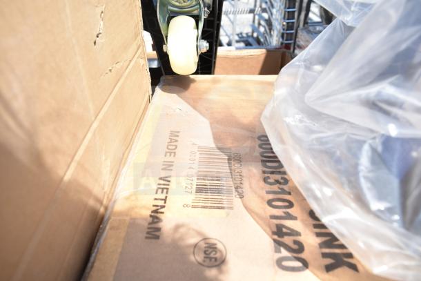 Cardboard box with "Made in Vietnam" marking, part of auction lot with new scratch and dent items. Includes high chair and shelves.