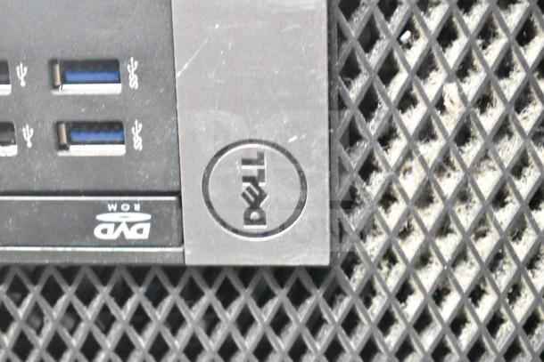 Dell computer tower showing front USB ports, DVD-ROM drive, and Dell logo, with grid ventilation design.