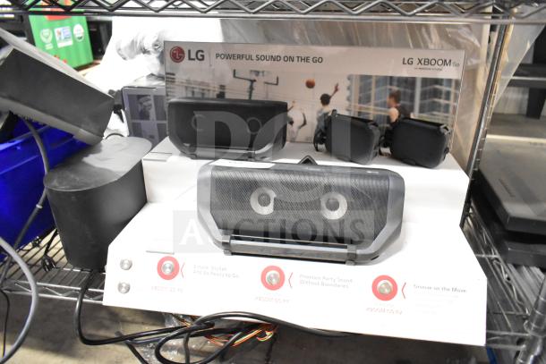 LG store display with XBOOM Go speakers, featuring clear branding. Includes multiple speaker models. Good condition.