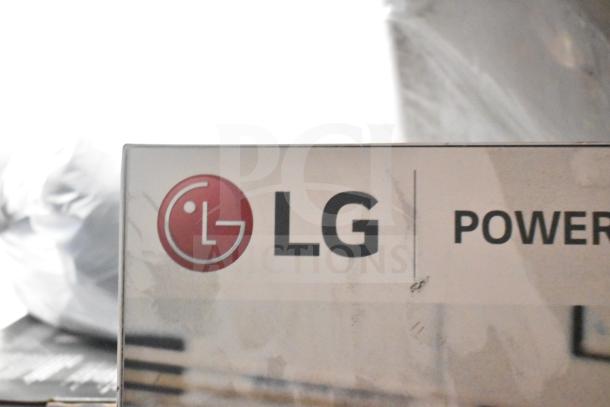 LG store display with speakers, featuring branding and visible surface wear.