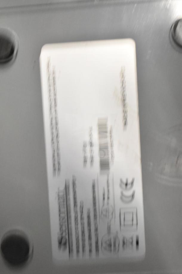 A label on a Sensormatic ZBSMPROE antenna deactivator showing barcode and compliance symbols.