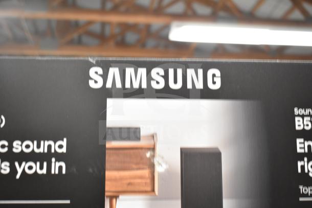 Samsung store display box featuring a sound bar, showing the Samsung logo and product imagery.