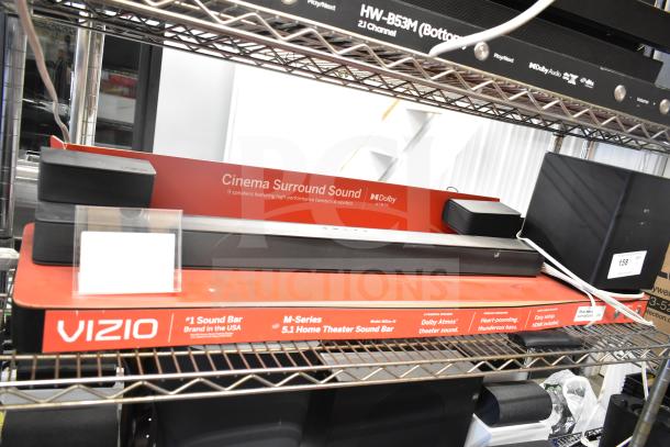 Vizio store display with Cinema Surround Sound Bar featuring 5.1 Dolby Atmos, 9 speakers, and high-performance tweeters.