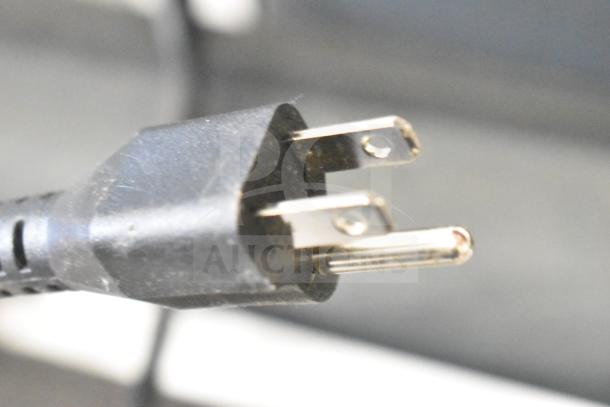 Black electrical plug from the Onn Store Display, showing metal prongs and cable housing, indicating power source connection.
