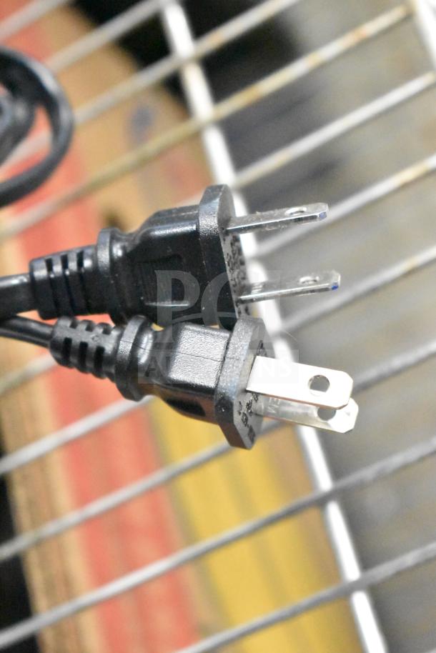 Black power plug for Vizio store display with sound bar, showing three-prong design on metal rack.