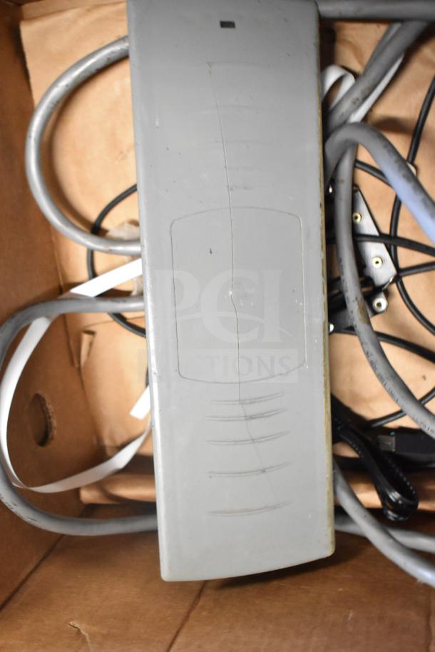 Lot of various items, including cables and a Sensormatic ZBSTPSP-L device. Worn condition, visible scratches.