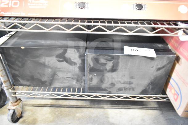 Two Samsung PS-WB65D wireless subwoofers on a metal shelf, visible wear, labeled with auction tag "162".