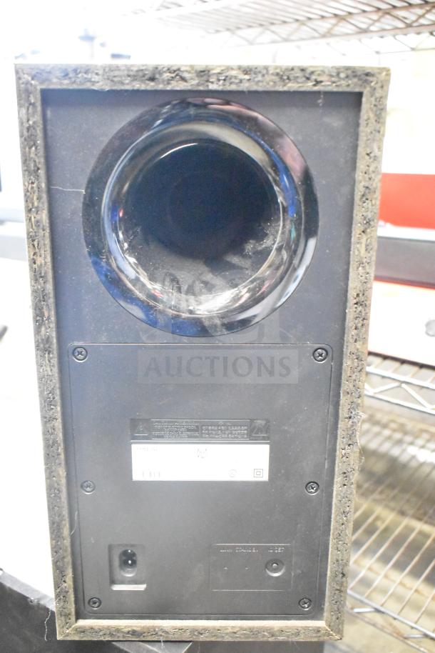 Samsung PS-WB65D wireless subwoofer, rear view showing input ports and labels. Condition appears used.