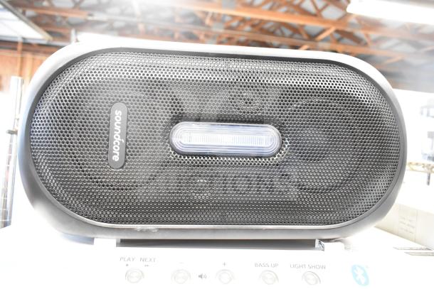 Soundcore Rave+ speaker in good condition, black mesh front with brand logo and central LED light strip.