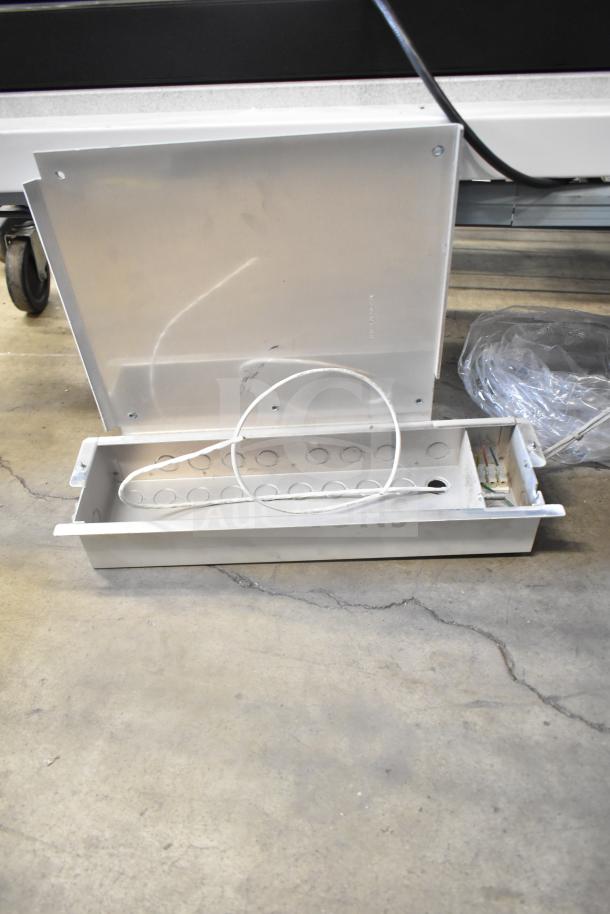 Metallic box with lid open, revealing wiring and circular cutouts, part of auction lot with Rave+ display and electronics.