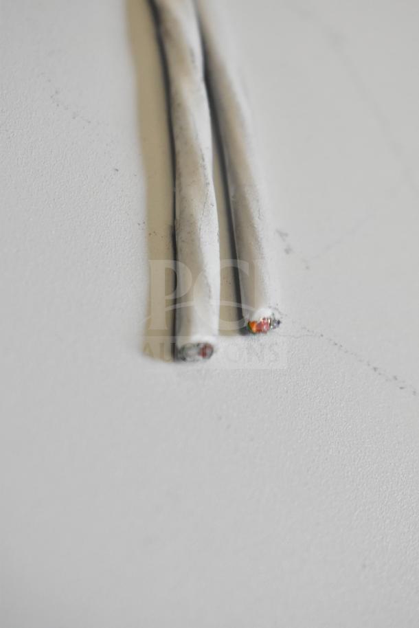 Close-up view of two white wires with exposed ends, showing internal copper and colored wiring. Part of a mixed auction lot.