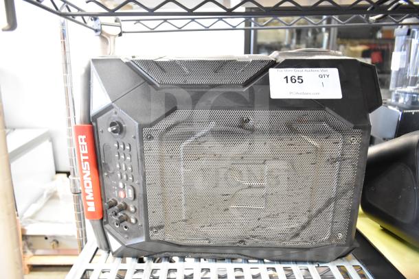 Monster speaker with rugged design, control panel, and branding. Black metal grille, minor wear visible, item tag "165" attached.
