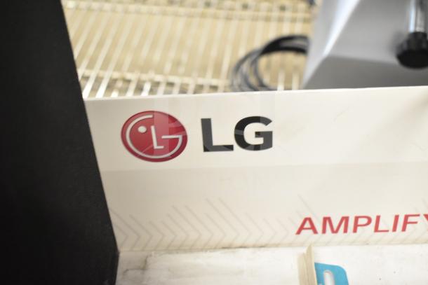 LG store display featuring a sound bar and two speakers. Visible LG logo on display.