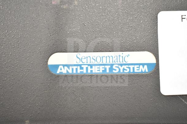 Sensormatic Anti-Theft System label on black surface. Auction for 8 detectors.
