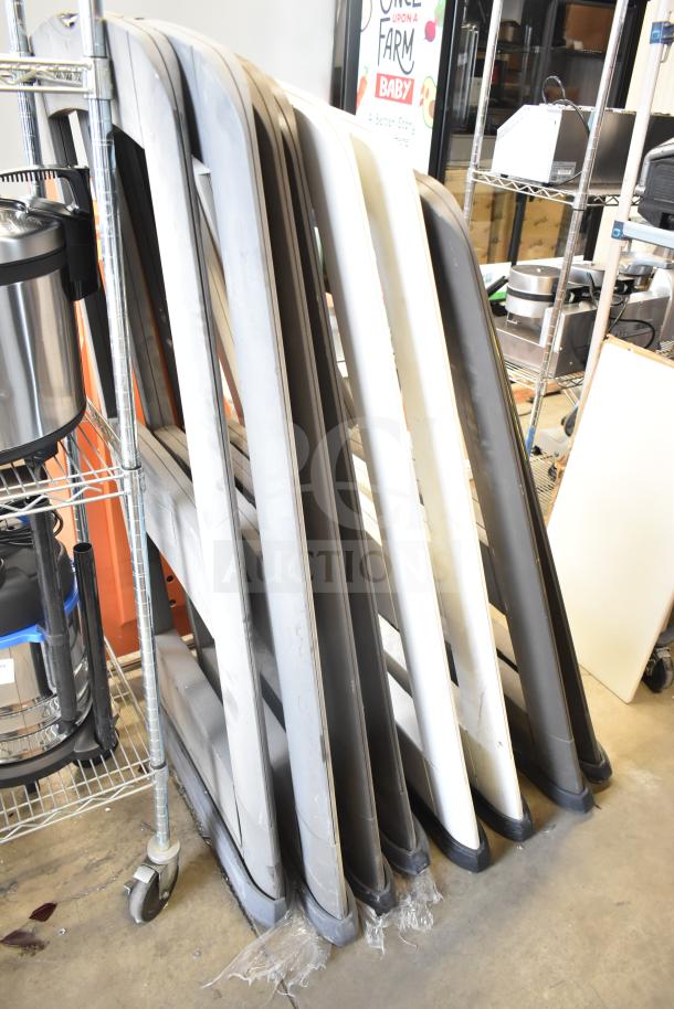 Eight Sensormatic antitheft detectors stacked in warehouse, in used condition, varying colors of gray and white.