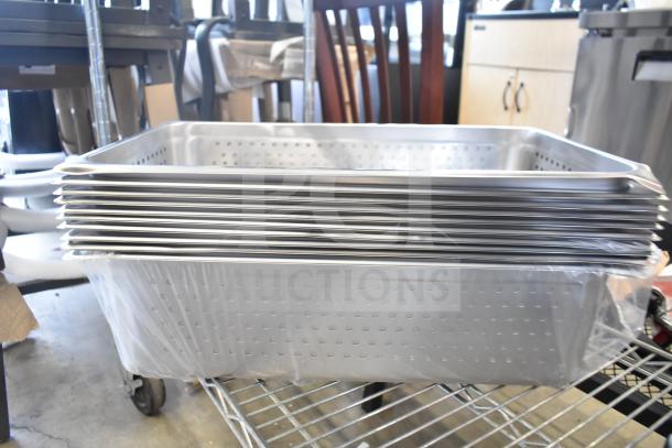 Stack of 15 brand new drop-in bins with minor scratches. Stainless steel, perforated, on warehouse shelf.