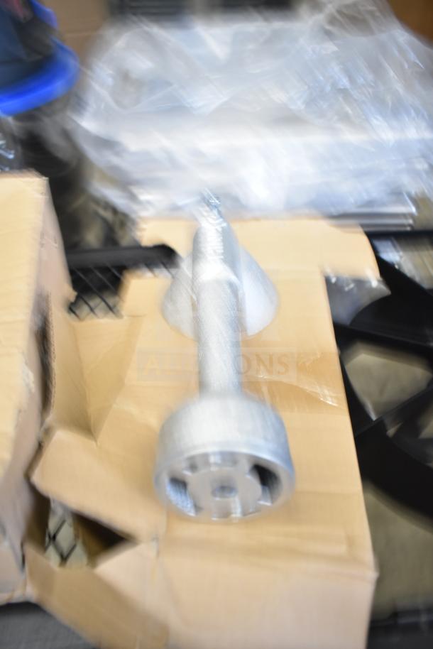 Blurred image of a component in packaging, possibly related to a 2 burner propane gas range, new but labeled scratch and dent.