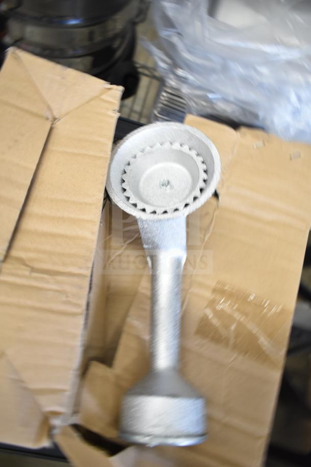 Alt text: New 2 burner propane gas range, shown inside a cardboard box. Features a compact design with minor scratches.