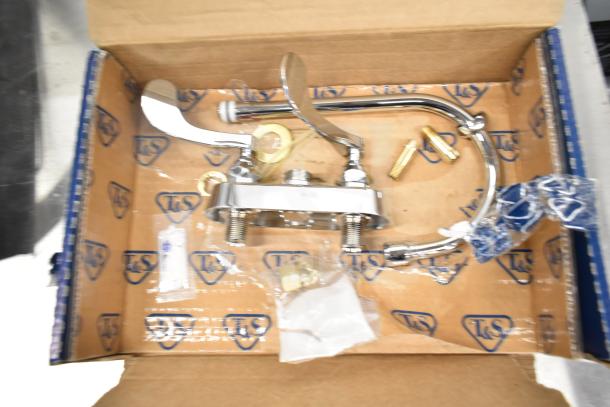 New American Standard and T&S deck-mount faucets in box. Includes gooseneck spouts, wrist blade handles, fittings.