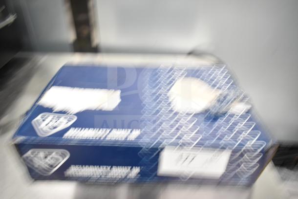 Blurred image of a box, potentially containing new scratch and dent items, including American Standard and T&S faucets.