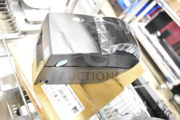 Brand new GoDex DT2x thermal label printer, scratch and dent condition, boxed with visible labels and packaging.