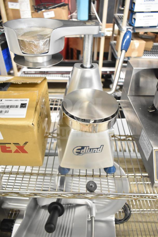 Brand new Edlund EBP-500 countertop patty press, 5" diameter, scratch and dent condition, visible logo on base.