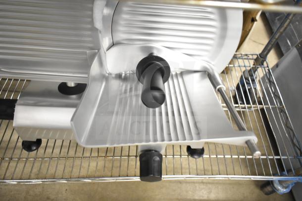 Brand new Globe Chefmate C12 commercial meat slicer with blade sharpener, 115V, 1 phase, minor scratches visible.