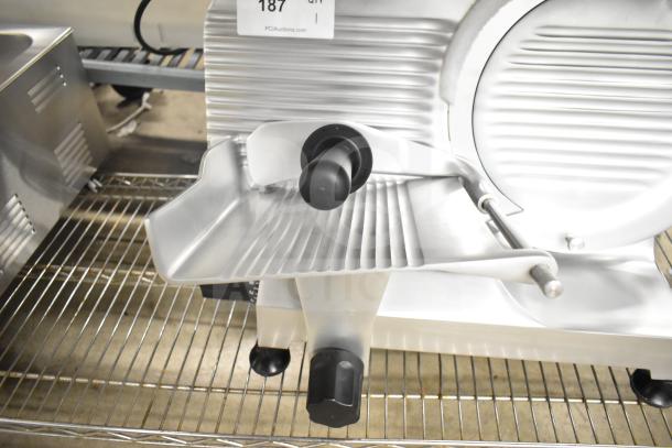 Brand new Globe Chefmate C12 meat slicer with blade sharpener, 115V, on a metal rack, scratch and dent condition.
