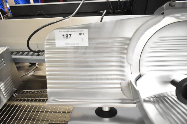 Brand new Globe Chefmate C12 meat slicer with blade sharpener, 115 volts, slight scratch and dent. Auction label visible.