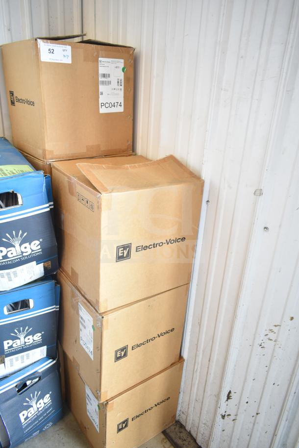 Boxes of Electro-Voice EVID-P6.2W speakers stacked in a storage area, labeled with model and auction info.