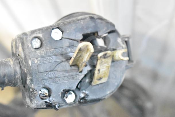 Close-up of a worn electrical plug of a Blodgett Mark V commercial convection oven, showing prongs and markings.