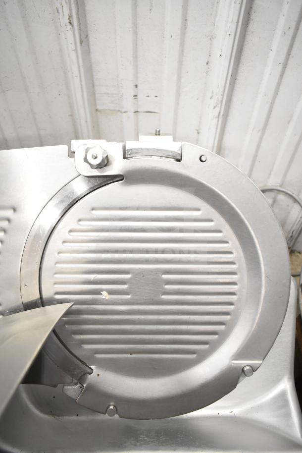 Hobart 2912 commercial meat slicer, stainless steel, good condition. Voltage: 115V, phase: 1. Ribbed detail on circular blade.