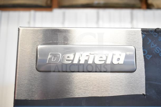 Brand new Delfield 6051XL-S commercial 2-door reach-in cooler, 115V, 1 phase, with a visible logo and slight scratches.