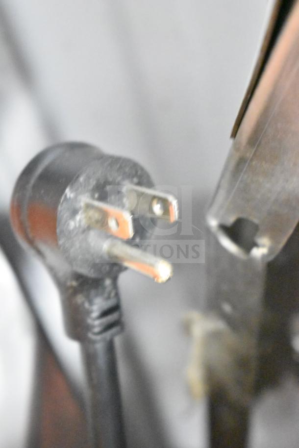 Close-up of a power plug for a 2025 True TVM-48SL-HC commercial cooler, showing a standard 115-volt plug.