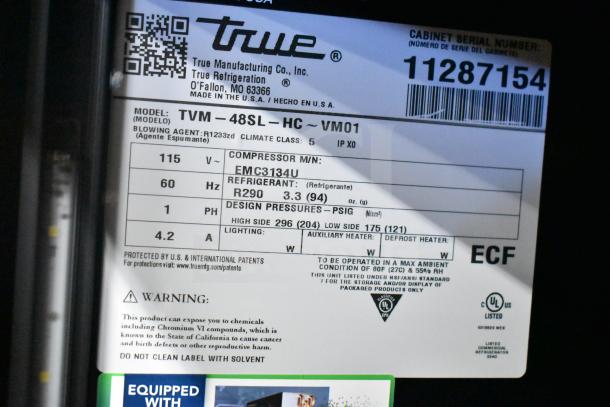 "Brand new 2025 True TVM-48SL-HC commercial reach-in cooler merchandiser label, showing specs and warnings."