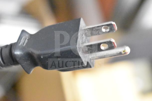 A close-up of a power plug for a Mettler Toledo commercial countertop scale, emphasizing its functionality and readiness for use.